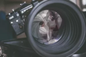 Woman posing in lingerie reflected in the camera lens