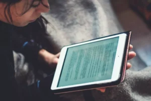 Woman holding tablet reading 