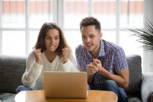 Couple looking at laptop screen for fantasy sports rankings