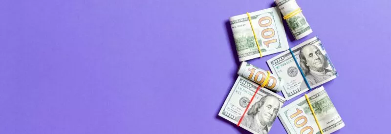 Surcharge vs cash discount bills on a purple background.