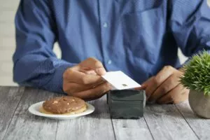 a man at a table with a plate of cookies paying through restuarant credit card processing