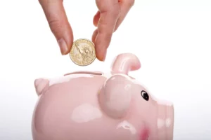 person dropping coin into piggybank - commercial business loan