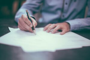 person writing on business papers impact analysis