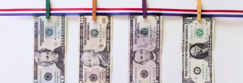 U.S. dollar bills hanging on line with laundry clips by someone who found out what is a cash advance fee