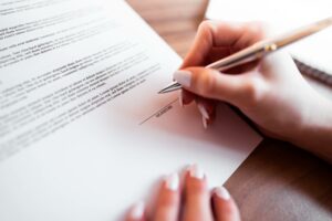 female hand signing a contract getting a business loan