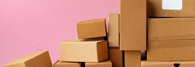 a pile of boxes against a pink background that was bought from an inventory loan