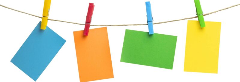 colorful note cards hanging on a string with clips ready for someone to write how to write a business plan