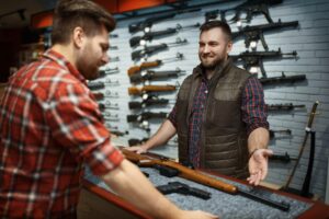 man shopping for gun at gun store asking male cashier how much for a gun license 