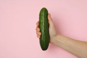 hand holding cucumber - sell adult toy