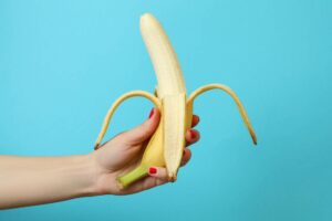 woman's hand holding banana - sell adult toys