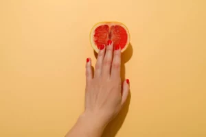 woman's hand touching grapefruit - how to sell sex toys from home