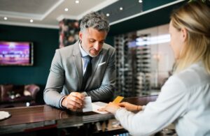 businessman checking in at hotel lobby being told about the temporary authorization