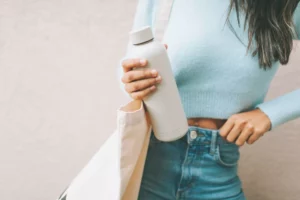 woman holding reusable water bottle - what products I can sell