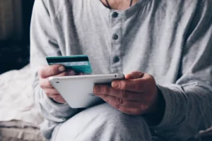 person entering card information on tablet to pay off average credit card processing fees