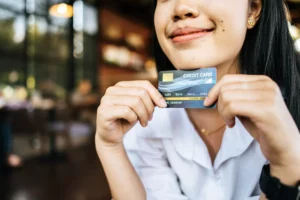 woman smiling and holding card while explaining credit card transaction fees