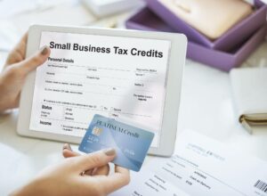 hand holding tablet that says "small business tax credits" for deductions