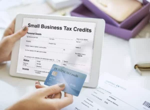 hand holding tablet that says "small business tax credits" for deductions