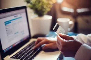 person entering credit card information into laptop as a way to accept credit card payments online