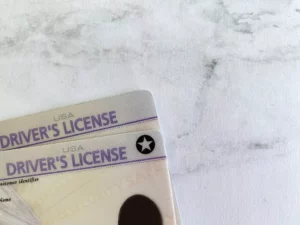 driver's license used for KYC against marble background - KYC meaning