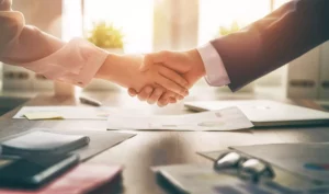 two business people shaking hands after leaning about limited liability company