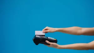 arms holding out a credit card reader against a blue background