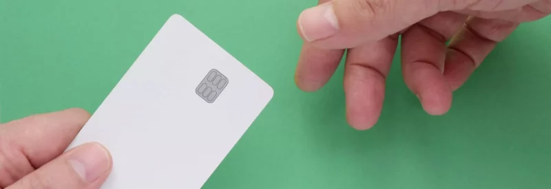 credit card that will be processed with a payment service provider being handed from one hand to another hand against a green background