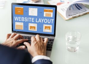 man typing on laptop designing website layout on website builder
