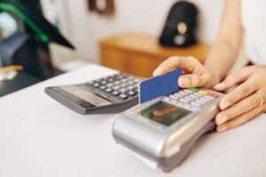 woman's hands swiping credit card on terminal thanks to her payment service provider