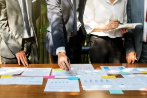 corporate employees reviewing a table scattered with documents explaining what is an LLC