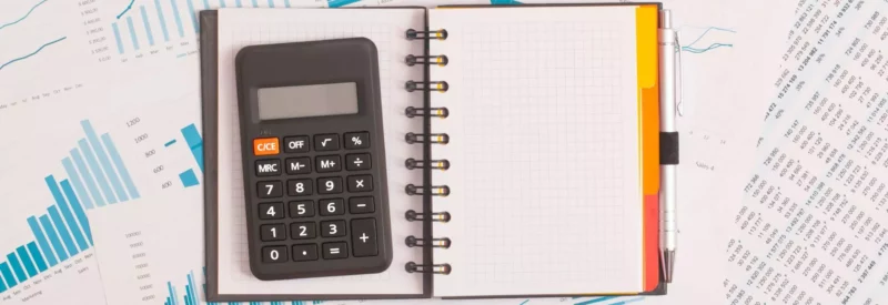 calculator on notebook on top of financial documents detailing reason for ACH return code R31