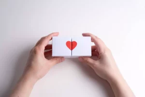 a person holding two blocks together to forms a heart symbolizing how to create a dating app