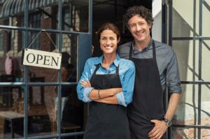 business-owning man and woman wearing aprons and pondering an LLC vs sole proprietorship