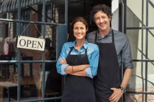 business-owning man and woman wearing aprons and pondering an LLC vs sole proprietorship