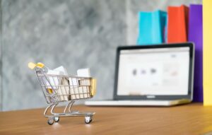 a miniature shopping cart in front of a laptop that shows a search of how does afterpay work 