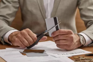 businessman cutting a credit card in half because his business is on the Mastercard MATCH list