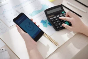 a business owner calculating the funds received from microlenders with their calculator and phone