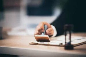 A hand holding a stamp to approve a mircrolending loan to a business