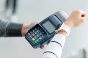 A customer using contactless payment on a terminal after business owner decided to use paypal or square payment methods