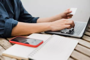 a business owner at a desk with their laptop and credit card going over the stripe processing fees