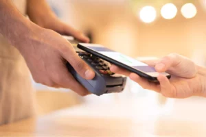 someone using their mobile phone to pay at merchant's terminal where the merchant will be charged a stripe transaction fee