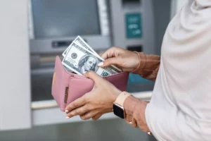 person at the ATM receiving funds after providing a SWIFT code for a payment transfer