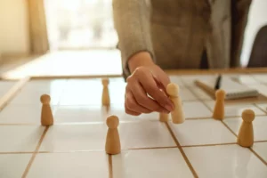 A person using wooden blocks of people to decide the board members after learning what is an s corporation
