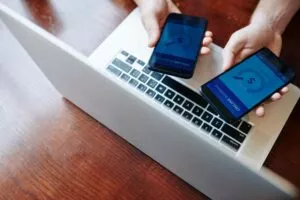 a mobile ach payment transfer being done using two phones with a laptop