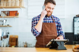 cafe worker taking a moto payment and inputting it into card machine