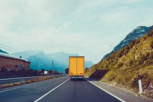 a yellow truck on a highway road to cross state lines after paying the dot number cost. 