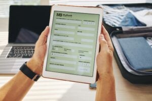 man holding tablet showing a form for an electronic check