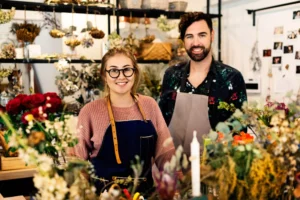 Two flower shop business owners smiling after being approved for a minority small business grant