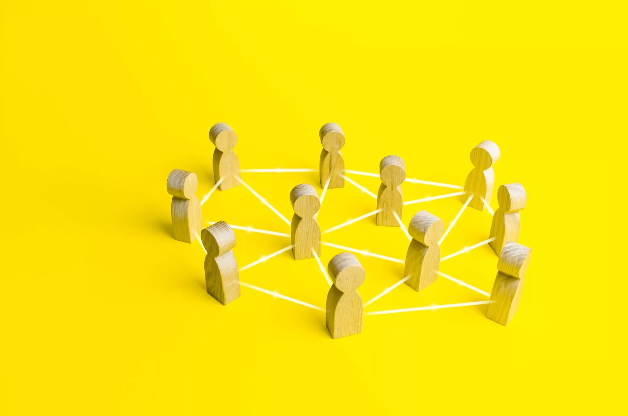wooden people blocks on a yellow background with lines to connect them to represent a pllc