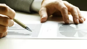 a person looking at a target consumer graph with a pen on a table