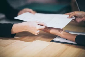 a person handing a permit that gives trucking authority to another person 